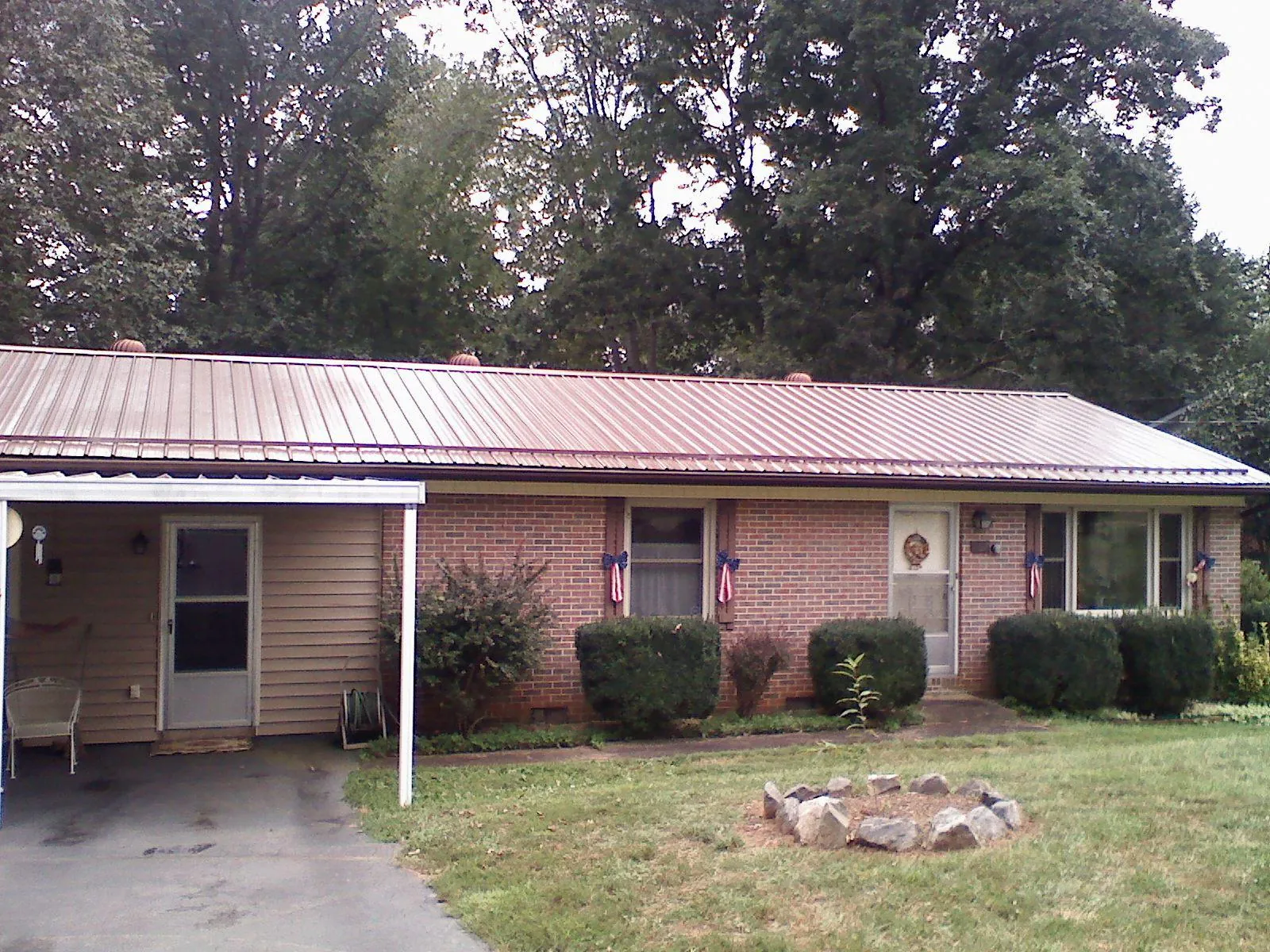 Bronze metal roof and carport on a brick ranch home — Roof Repair work by our crew in Forestdale